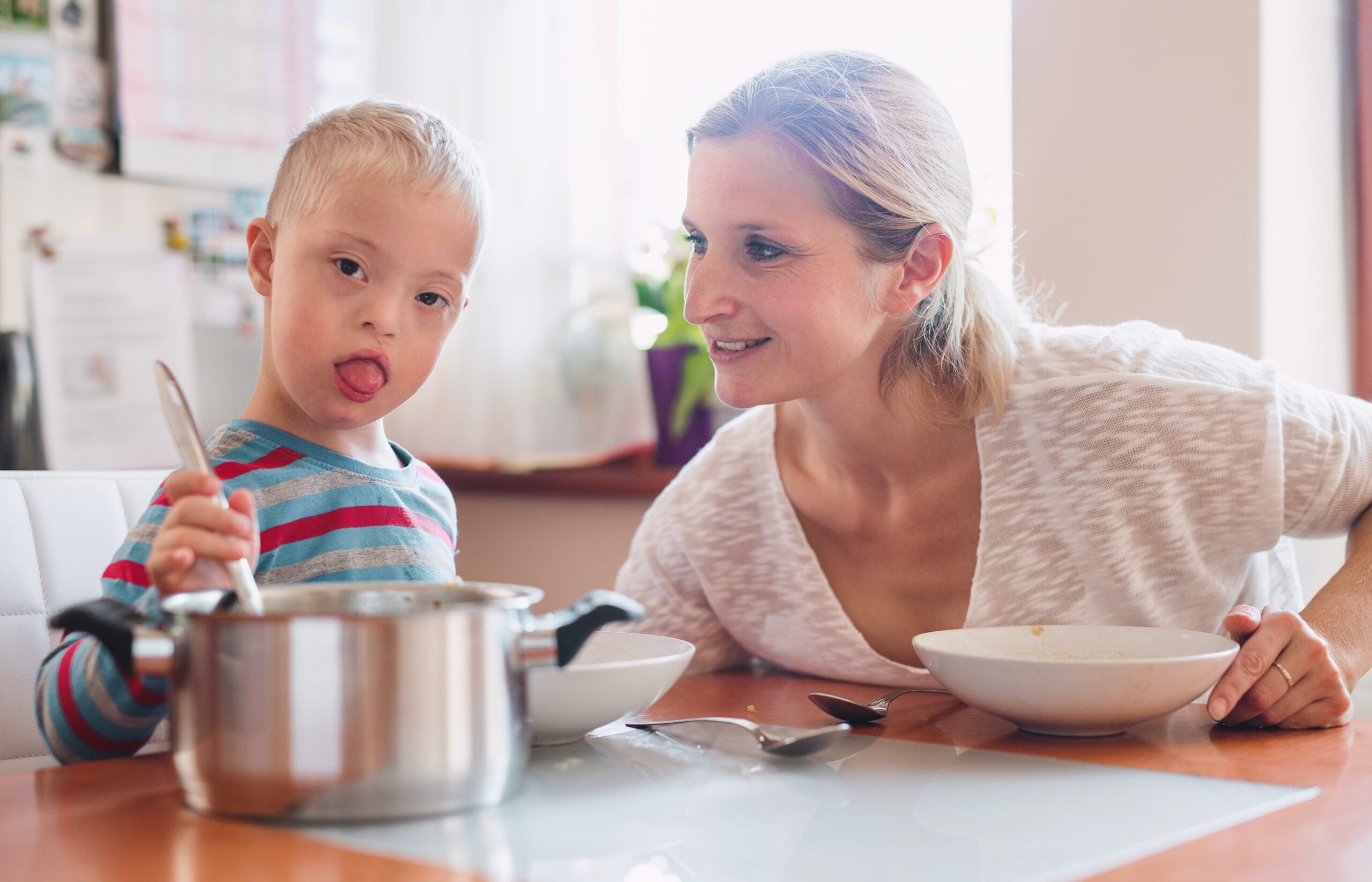 mother and boy with down syndrom cooking together